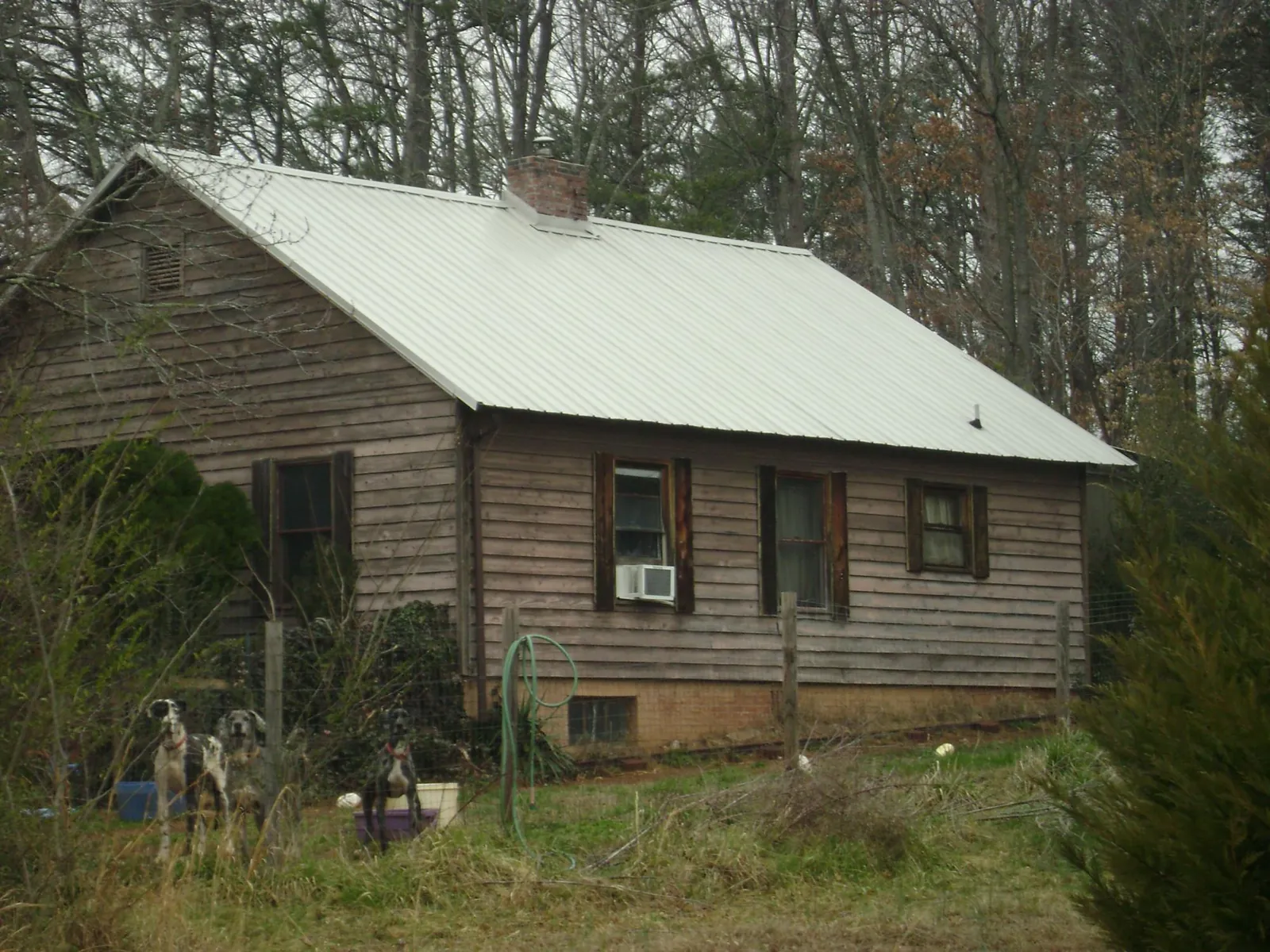 White metal roof on an old wood sided farmhouse, from a Metal Roof Installation job in Pinehurst